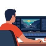 Person editing a landscape video on desktop computer with video editing software, smartphone on tripod nearby.